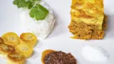 Un plat de bobotie sud-africain accompagné de riz, banane et chutney