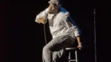 Kevin Hart assis sur un tabouret, un micro à la main, en novembre 2014