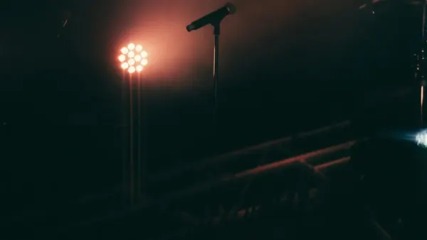 Un microphone sur scène sous des projecteurs, image d’illustration