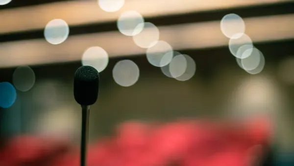 Microphone éclairé sur une scène, image d’illustration